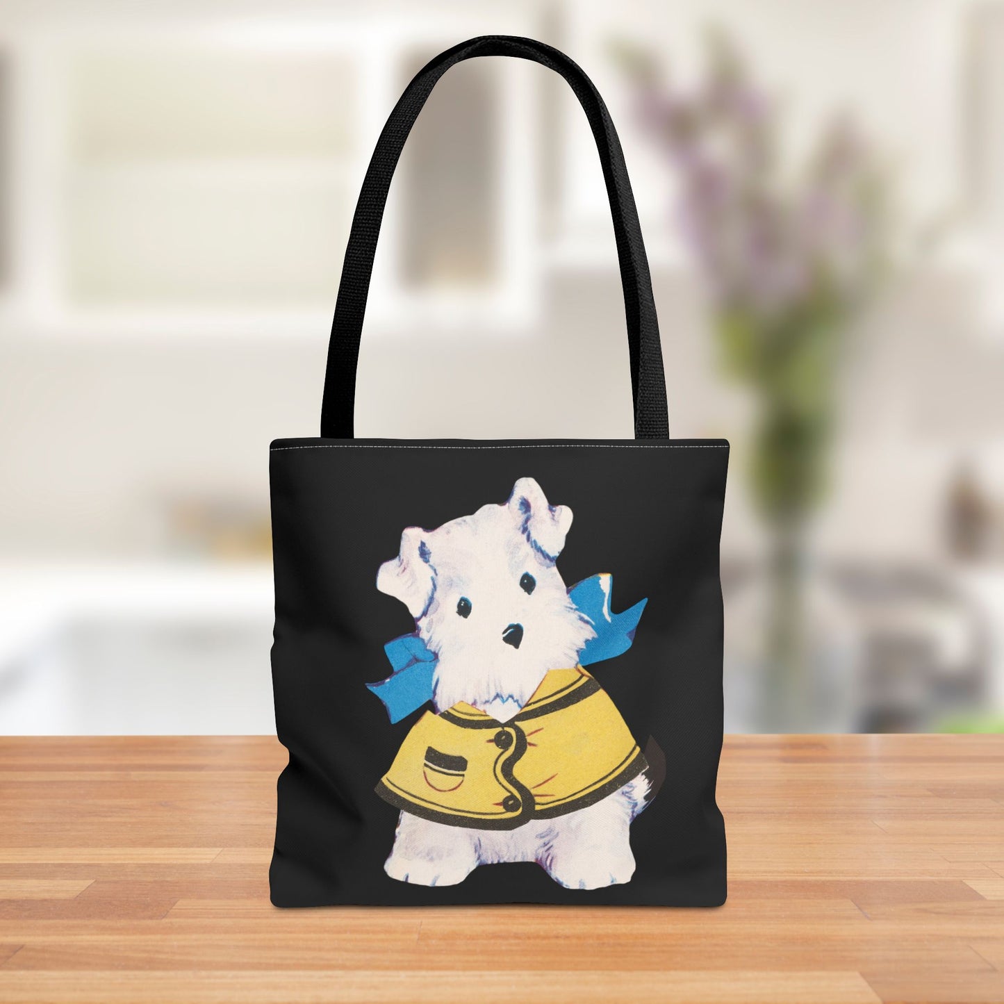 Front view of a polyester tote bag featuring a vintage illustration of Bitsy, the paper doll dog, in a yellow jacket and blue bow on a black background.