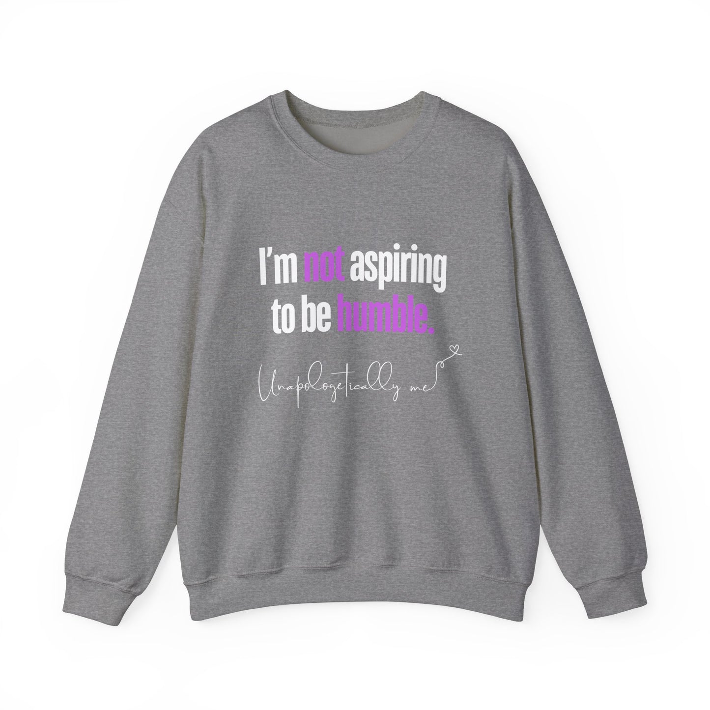A graphite grey sweatshirt featuring the quote "I'm Not Aspiring To Be Humble" in bold white and purple text, with "Unapologetically Me" script at the bottom.
