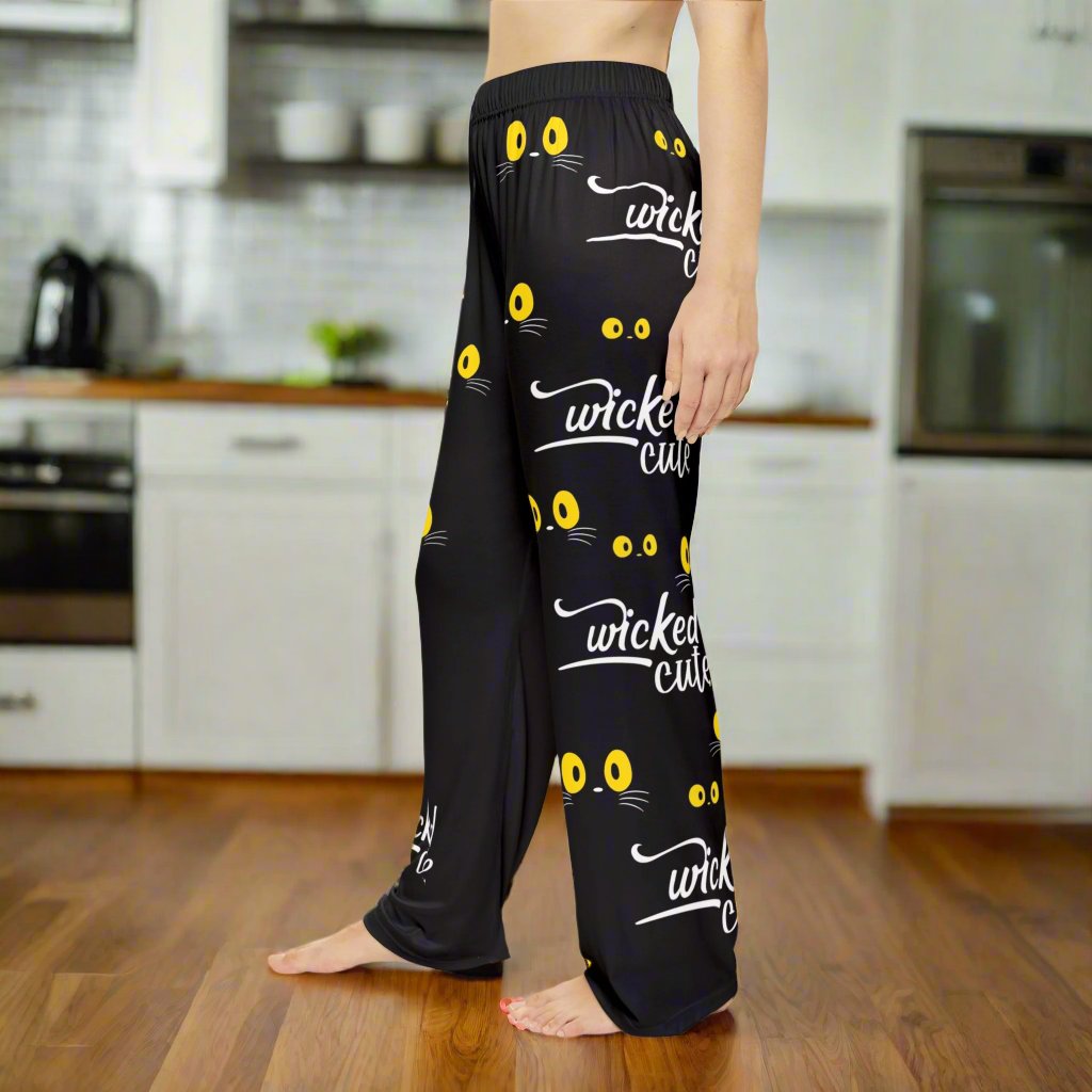 Left side view of Wicked Cute Black Cat Women's Pajama Pants showing the continuous pattern of yellow cat eyes and Wicked Cute text against a black fabric.