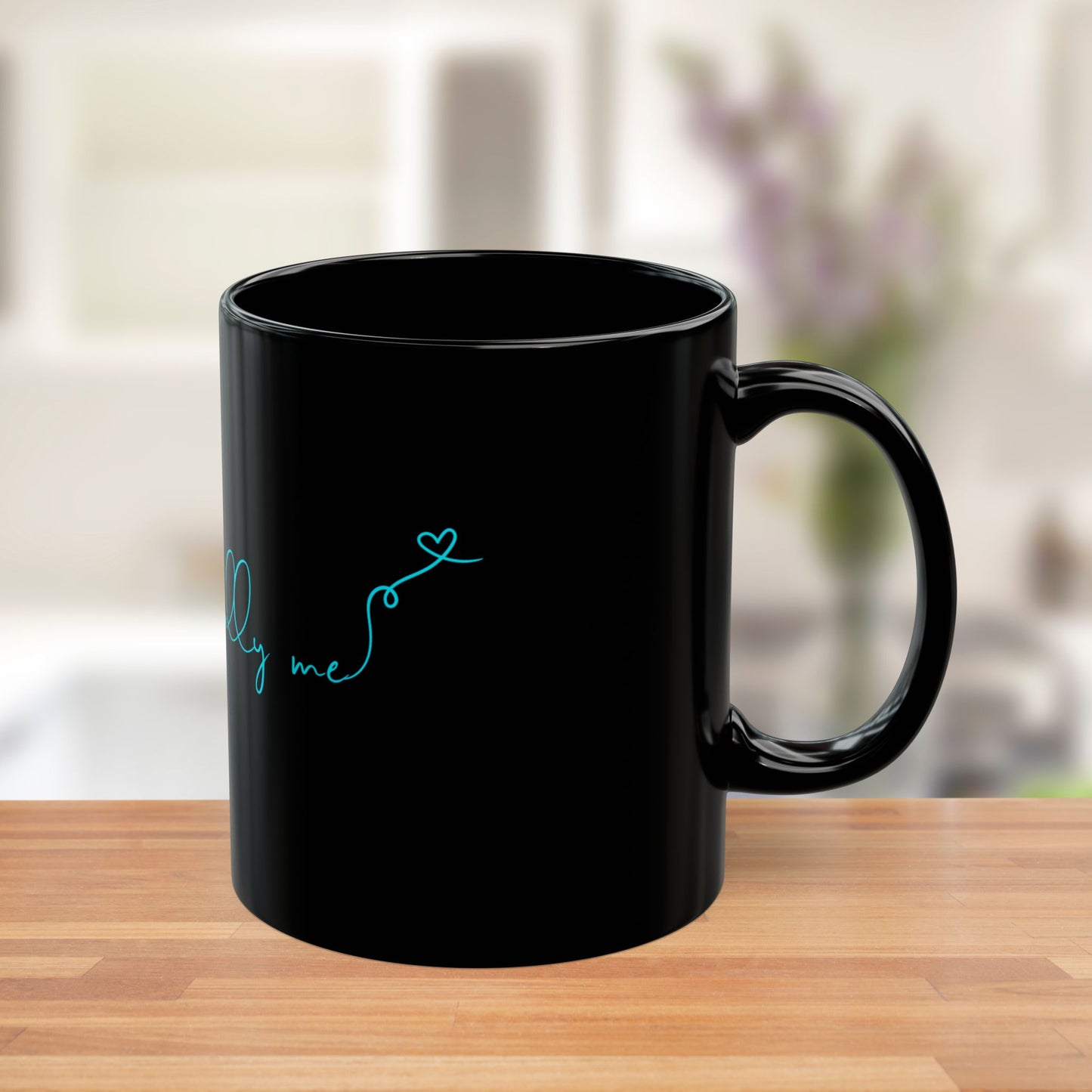 Side view of black ceramic mug with bold teal Unapologetically Me message.