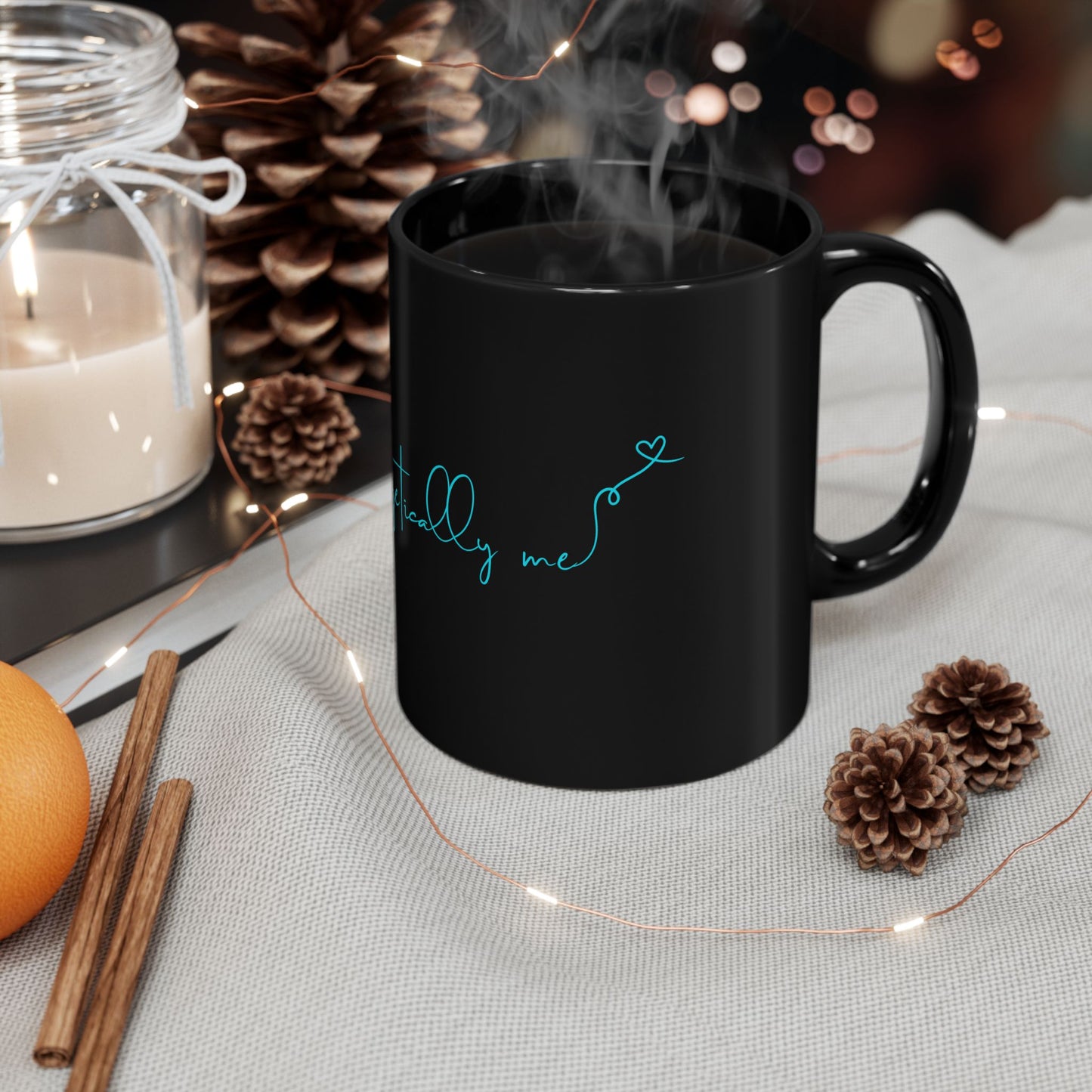 Lifestyle view of black ceramic mug with bold teal Unapologetically Me message.