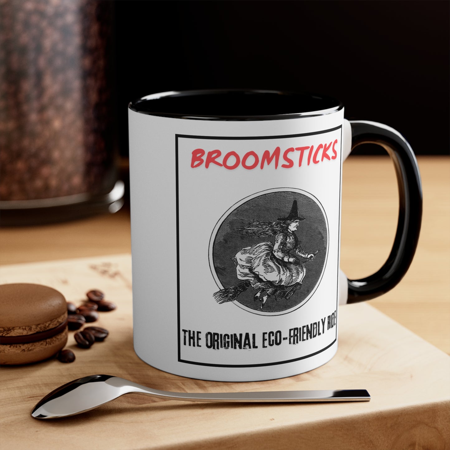 Black Interior: White ceramic coffee mug with black interior, featuring a vintage witch illustration and the text "Broomsticks - The Original Eco-Friendly Ride." Perfect for Halloween and witch enthusiasts.