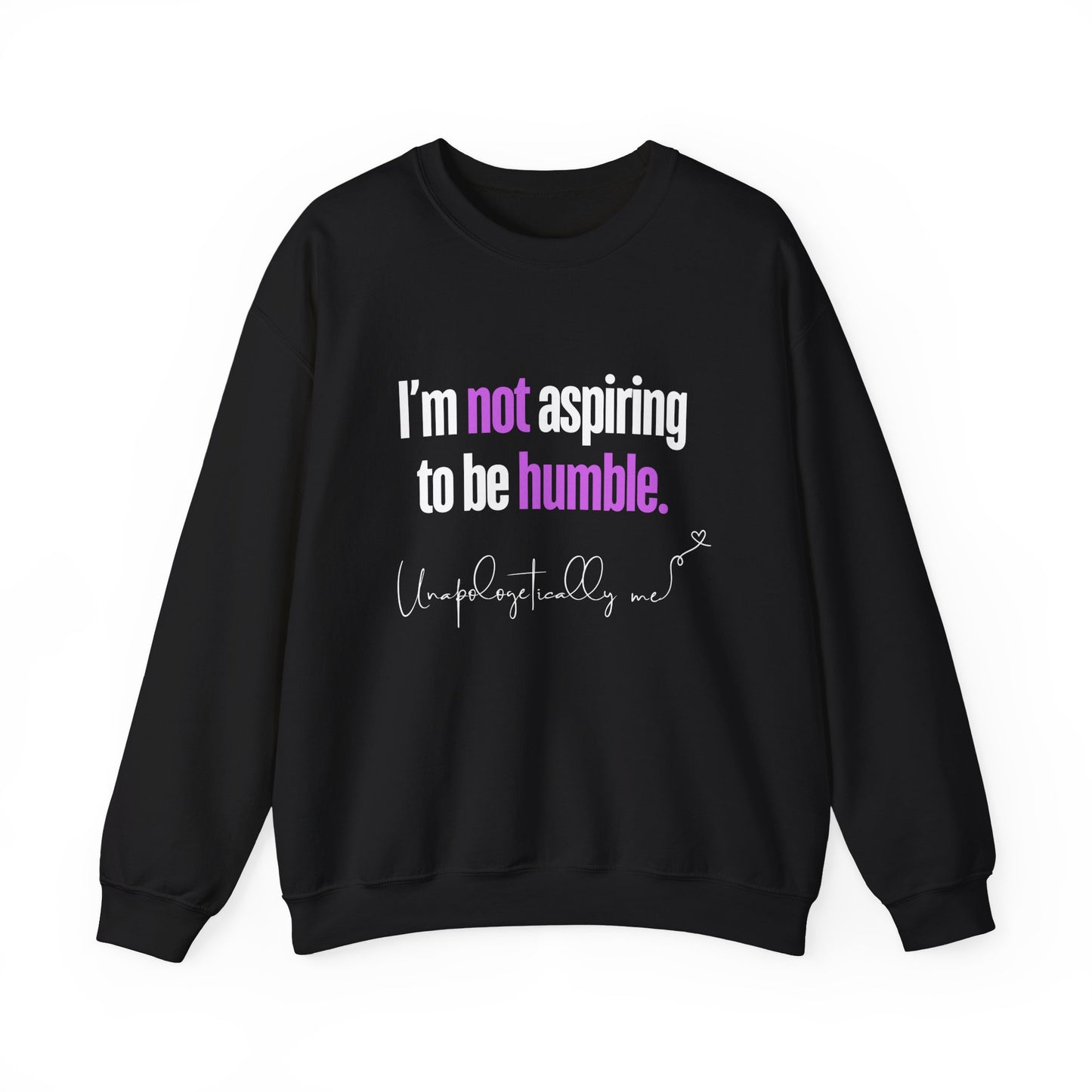 A black sweatshirt featuring the quote "I'm Not Aspiring To Be Humble" in bold white and purple text, with "Unapologetically Me" script at the bottom.