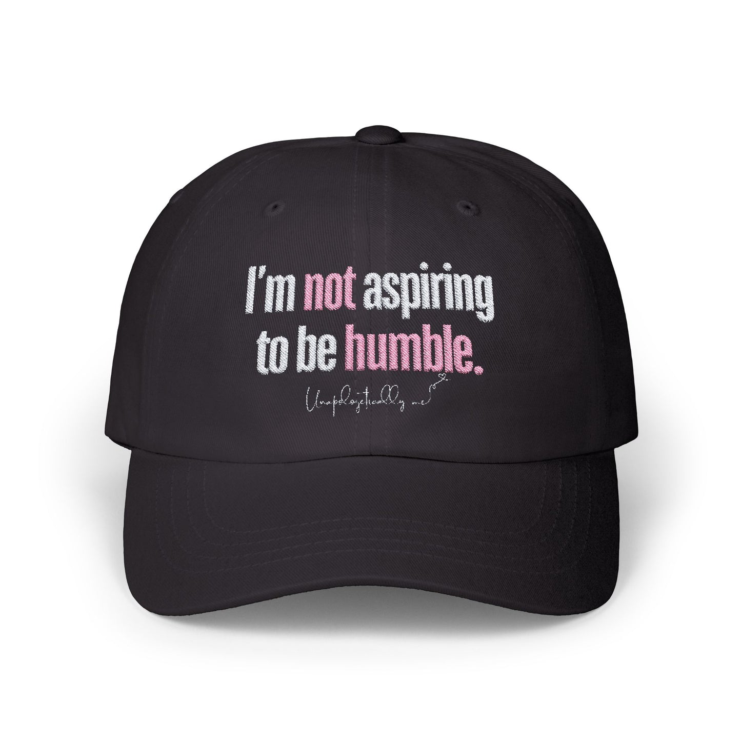 Front view of the black dad hat with the phrase “I’m not aspiring to be humble” embroidered in bold.