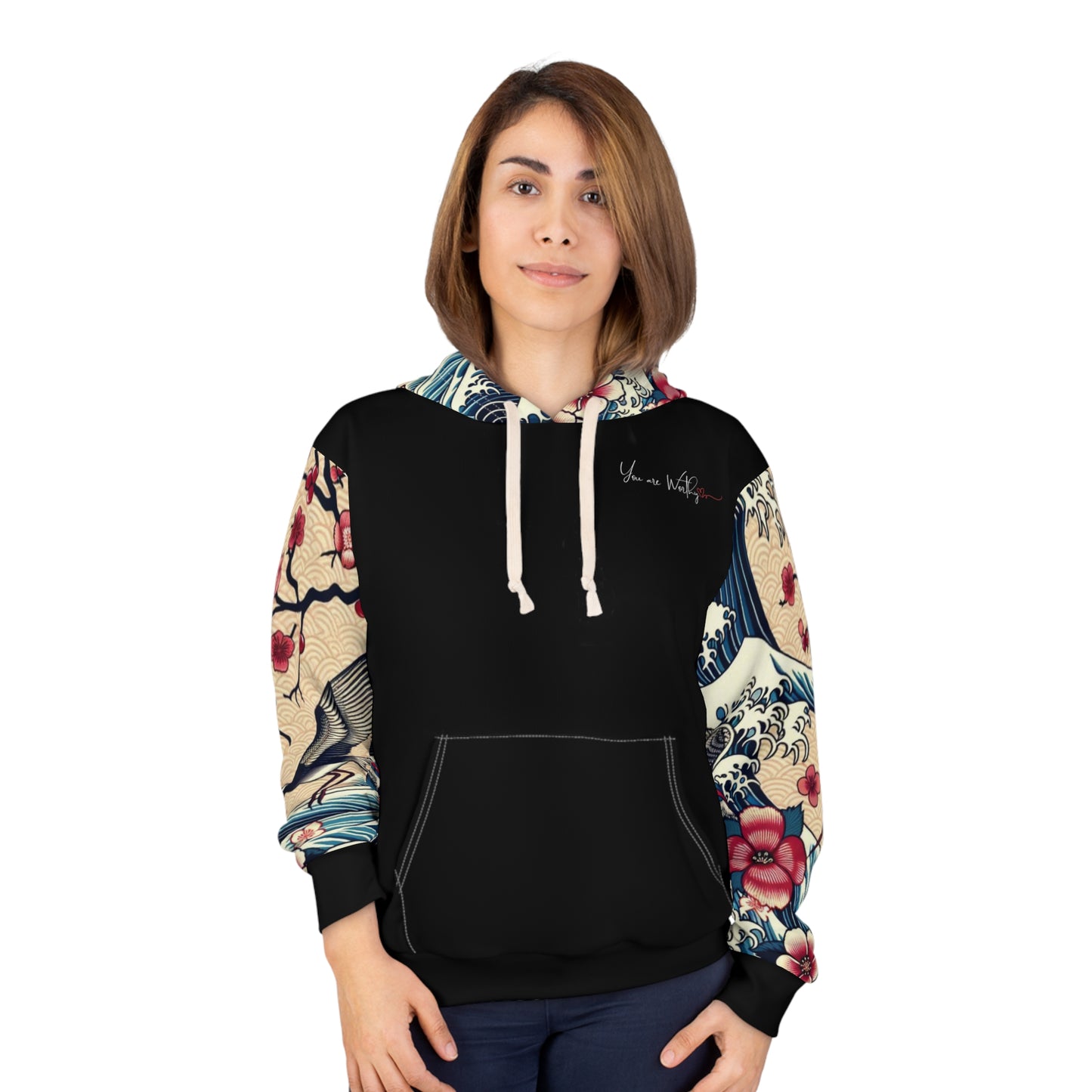 Female model wearing a black hoodie with Japanese floral print sleeves and 'You Are Worthy' message on the chest, styled with jeans.