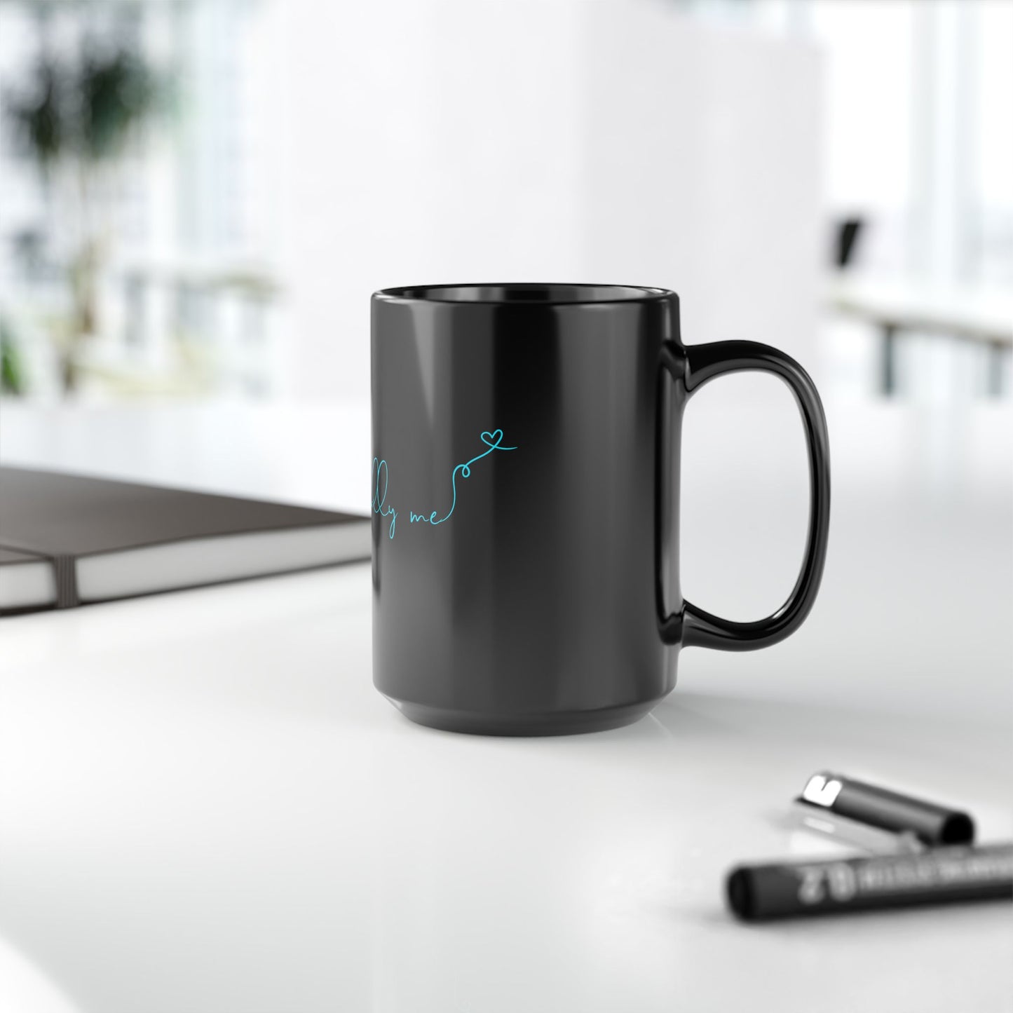 Side view of black ceramic mug with bold teal Unapologetically Me message.