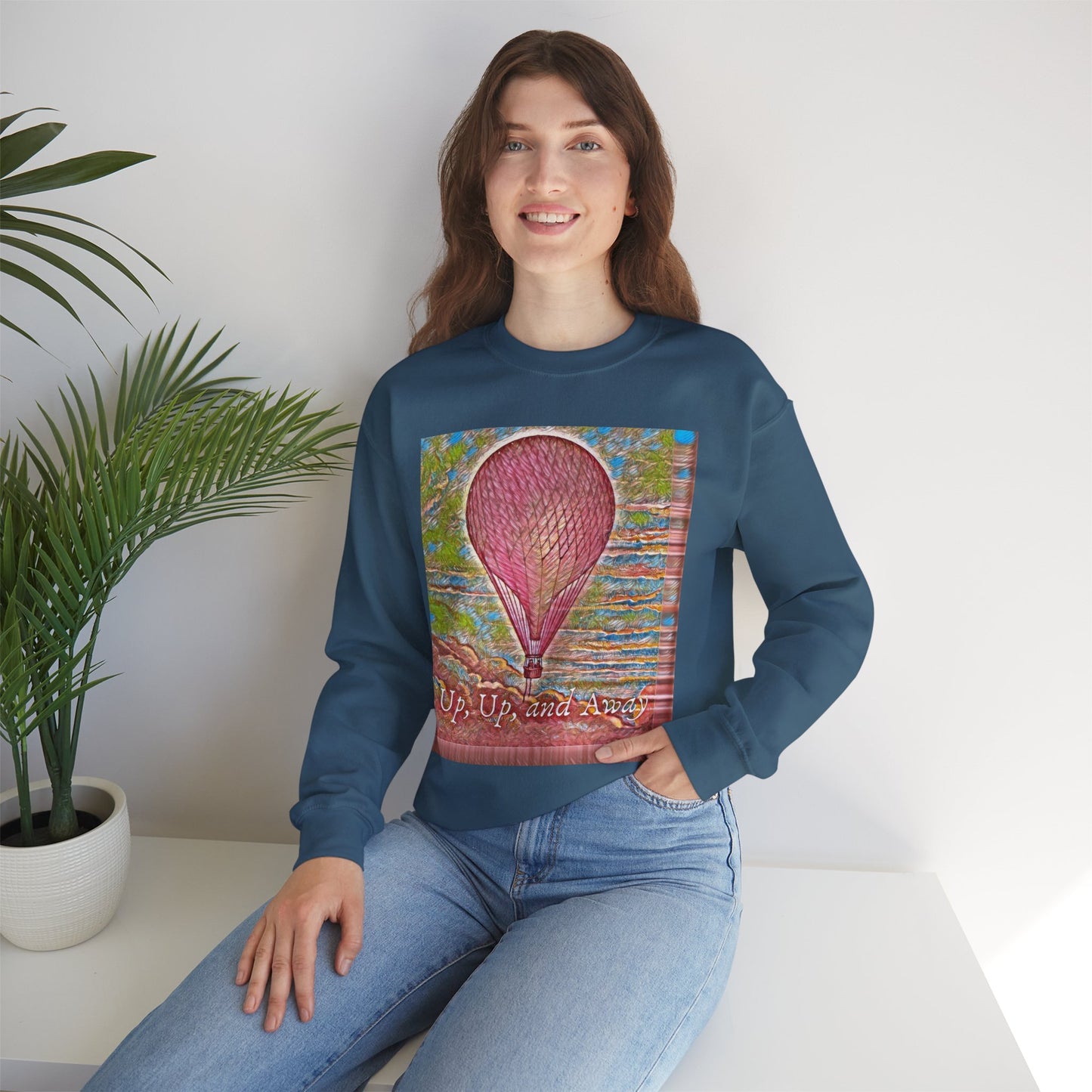 Lifestyle image of a woman wearing the pink hot air balloon sweatshirt in indigo blue, sitting indoors