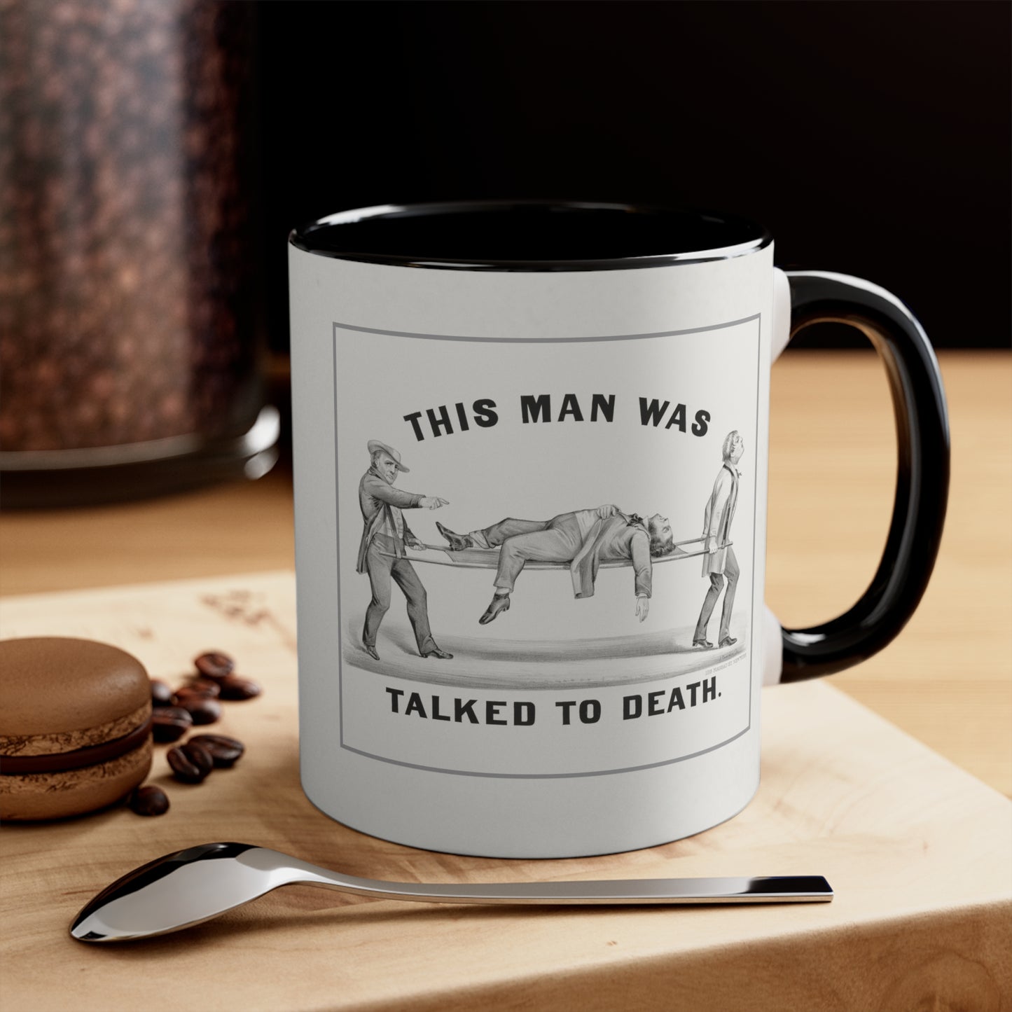 "Talked to Death" vintage humor mug with black handle and interior, placed on a table