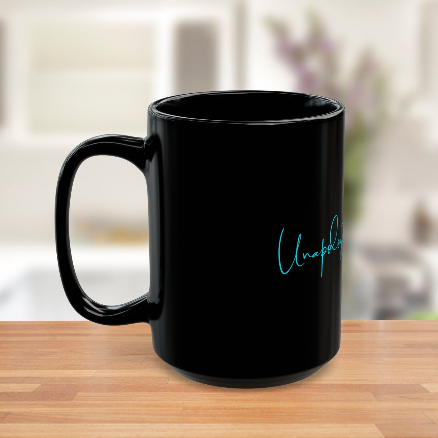 Side view of black ceramic mug with bold teal Unapologetically Me message.