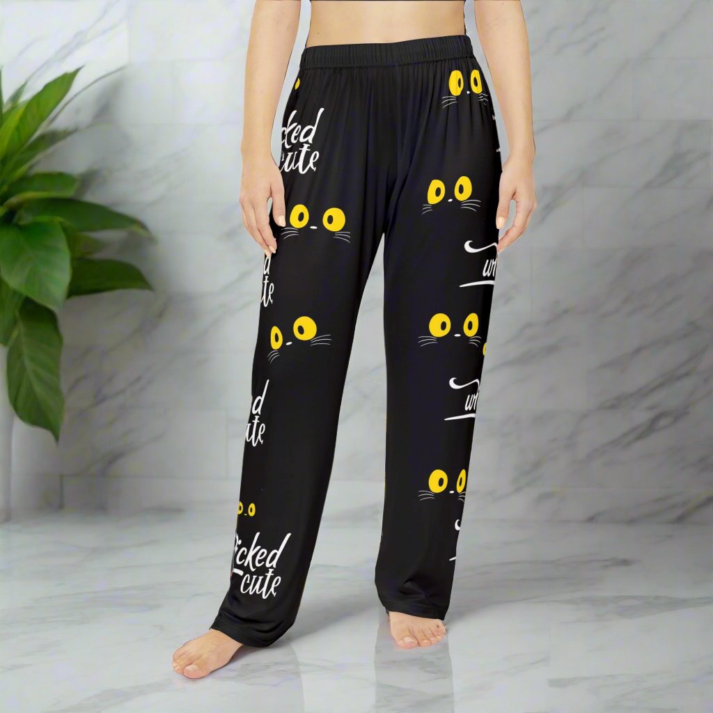 Front view of Wicked Cute Black Cat Women's Pajama Pants featuring an all-over print of yellow cat eyes and the words Wicked Cute on a black background.