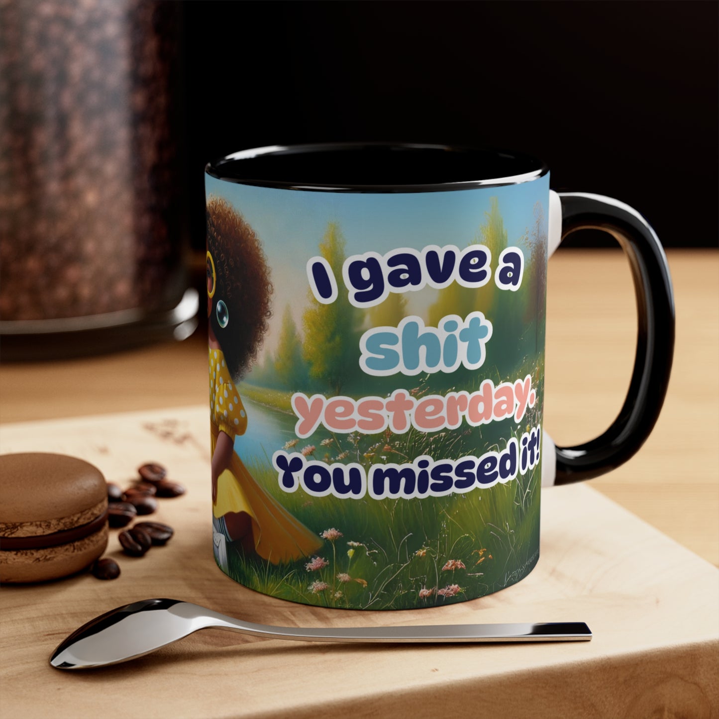 Coffee mug with humorous text "I gave a sh*t yesterday. You missed it!" and Afrocentric art, featuring a whimsical meadow background.