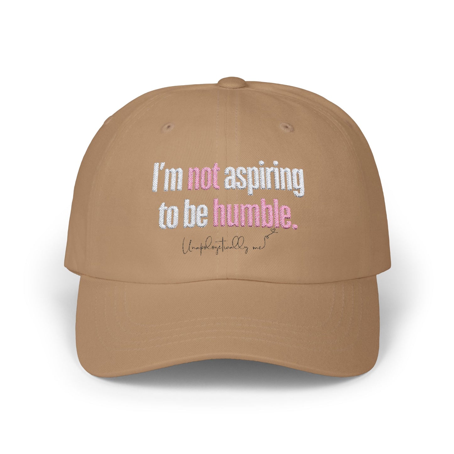 Front view of the Khaki dad hat with the phrase “I’m not aspiring to be humble” embroidered in bold.