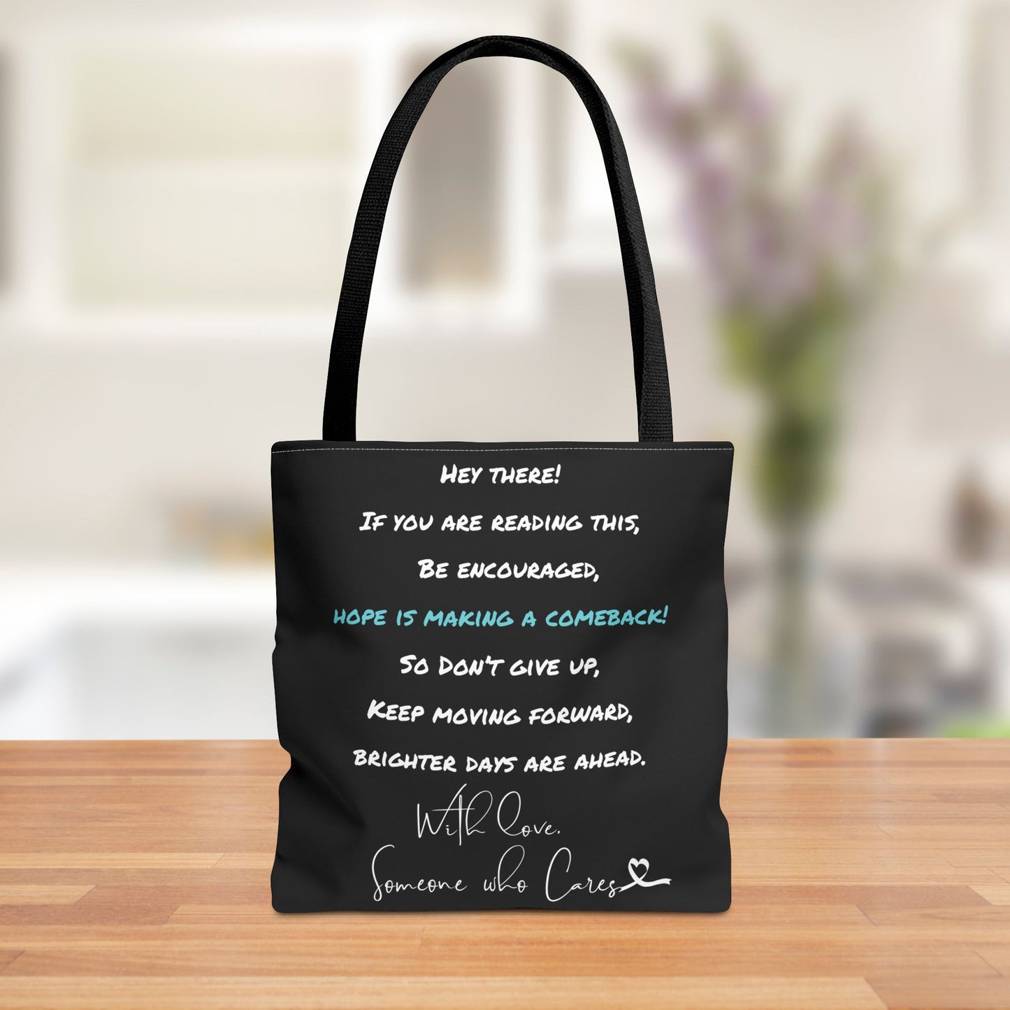 Front view of the "Hope is Making a Comeback!" tote bag featuring a positive message in white and teal lettering against a black background.