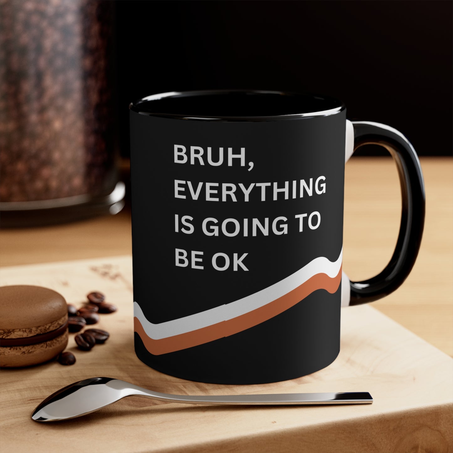 Bruh, Everything is Going to Be OK motivational coffee mug with black interior, shown on a wooden table with a spoon and coffee beans