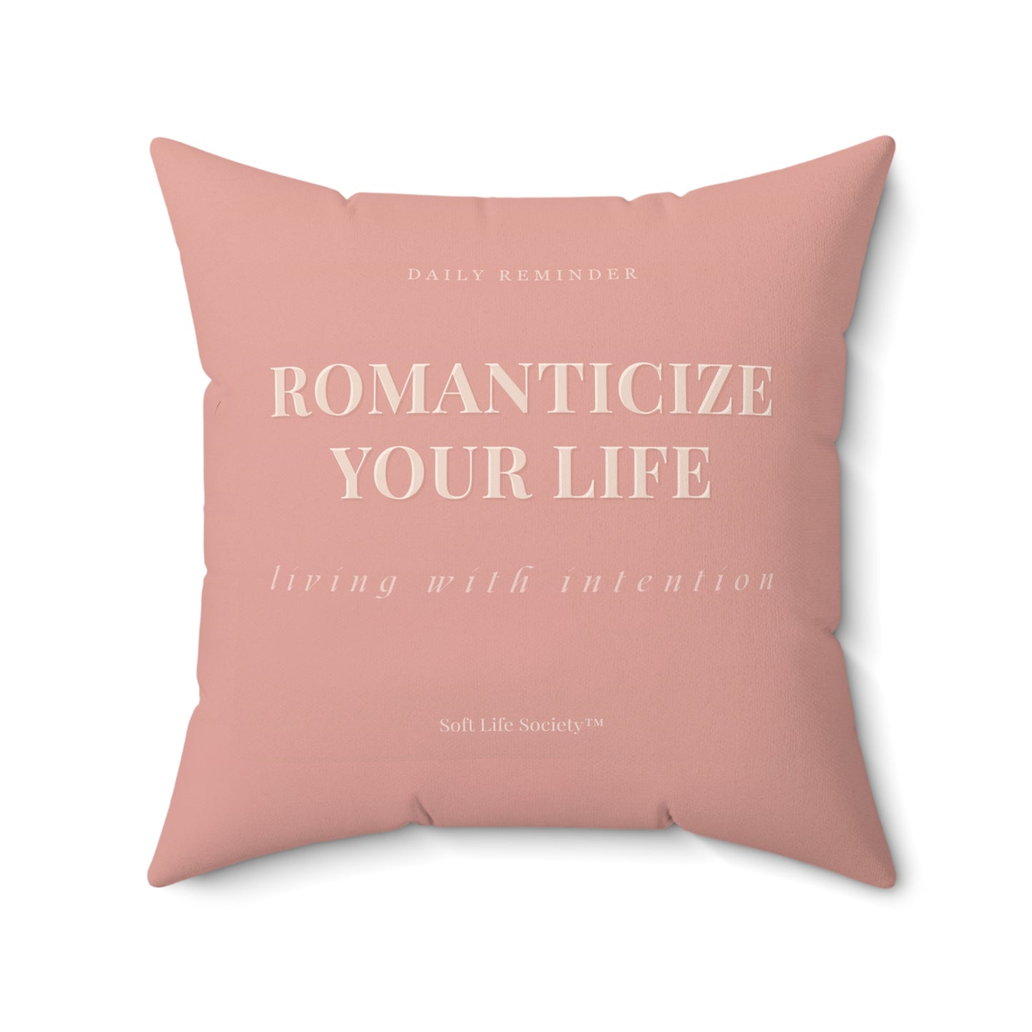Pink pillow with motivational text on a white background
