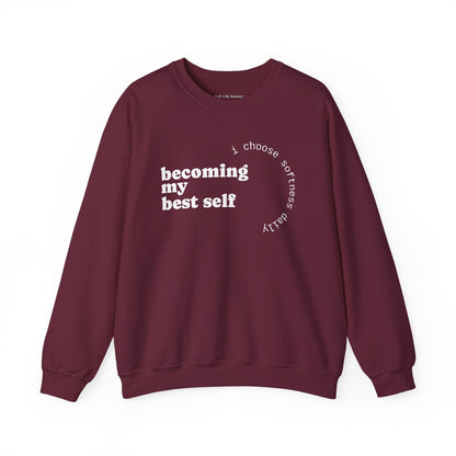 Maroon sweatshirt displayed flat showcasing the “becoming my best self” circular softness quote design.