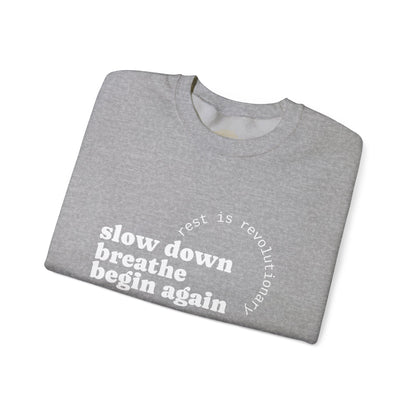 Folded gray sweatshirt with motivational text on a white background