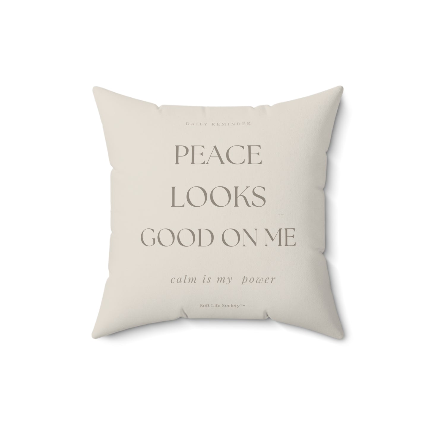Beige pillow with text 'PEACE LOOKS GOOD ON ME calm is my power' on a white background