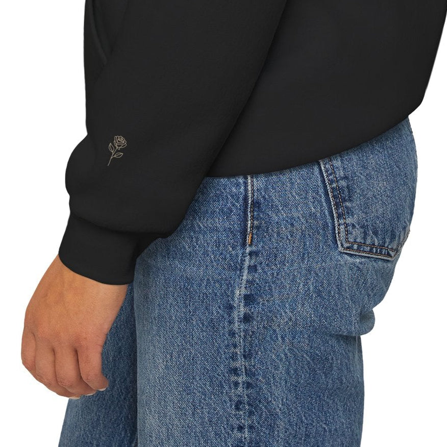 Close-up of subtle printed rose detail on the sleeve of a black Soft Life Society hoodie. 