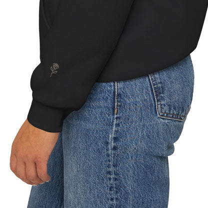 Close-up of subtle printed rose detail on the sleeve of a black Soft Life Society hoodie. 