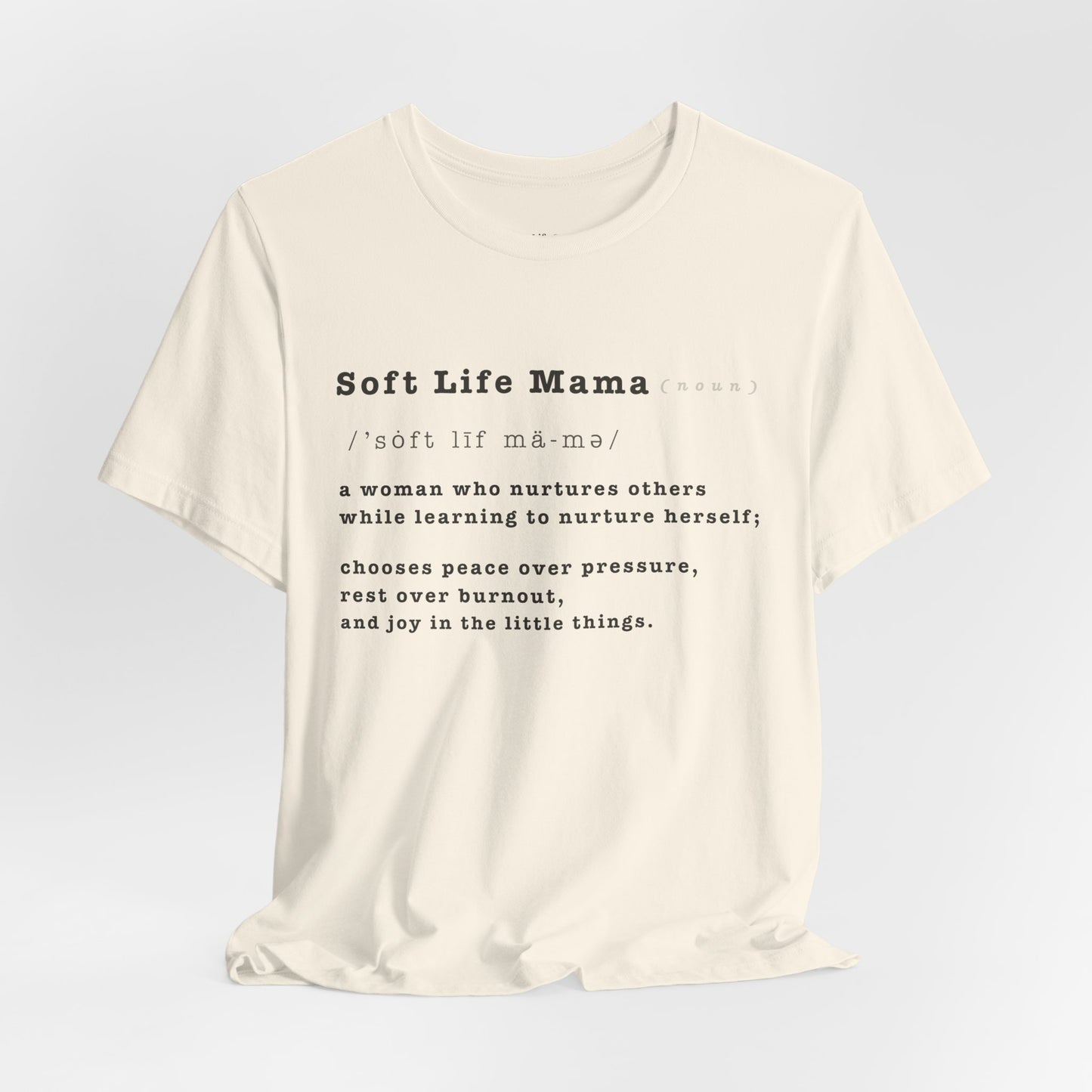 White t-shirt with 'Soft Life Mama' text on a light gray background