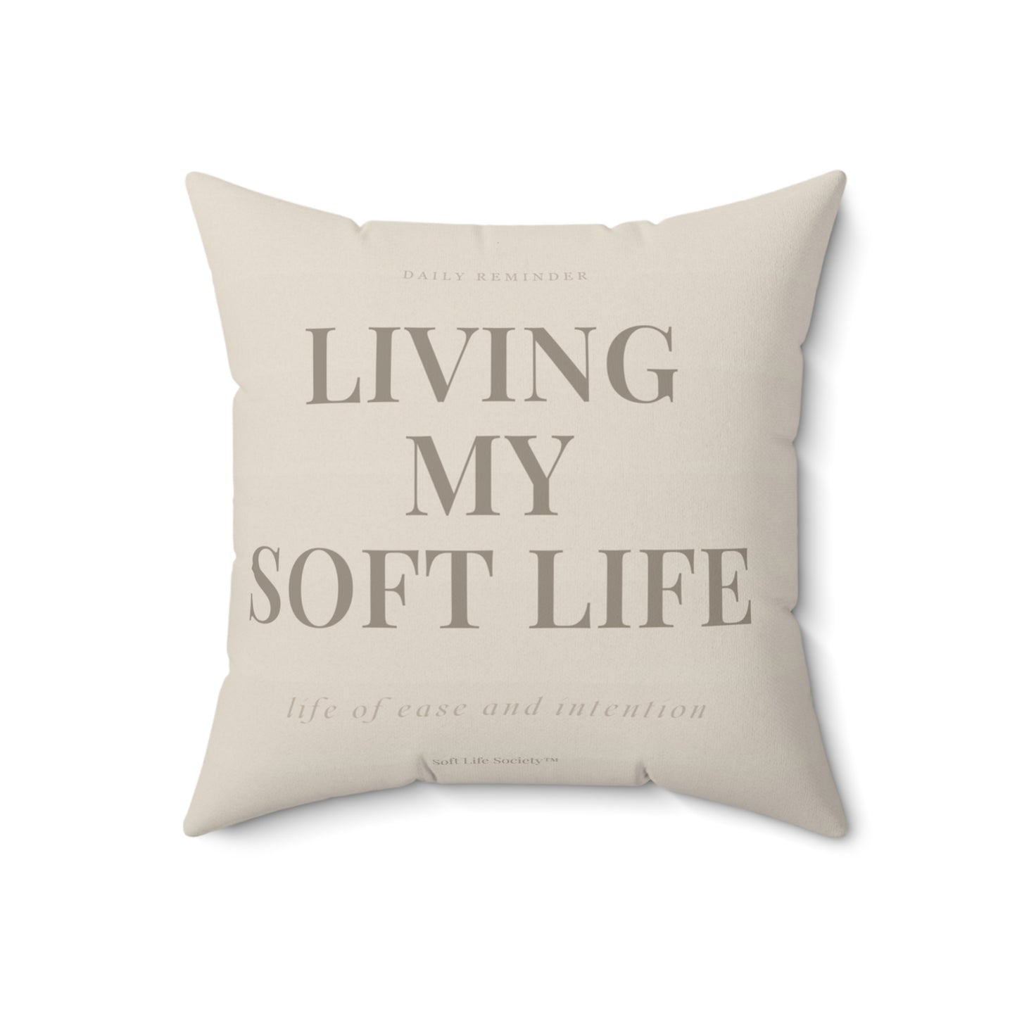 Beige pillow with text 'Living My Soft Life' on a white background