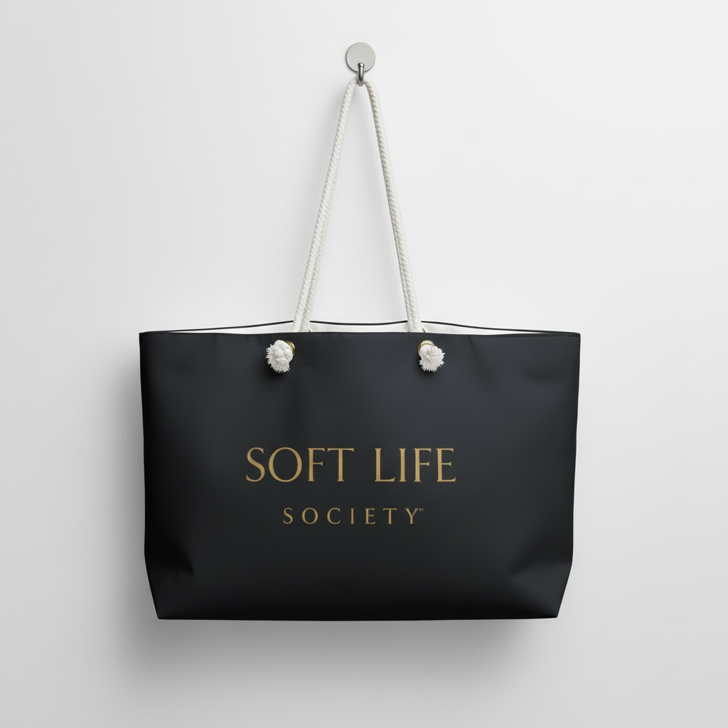 Black tote bag with 'SOFT LIFE SOCIETY' text on a light gray background