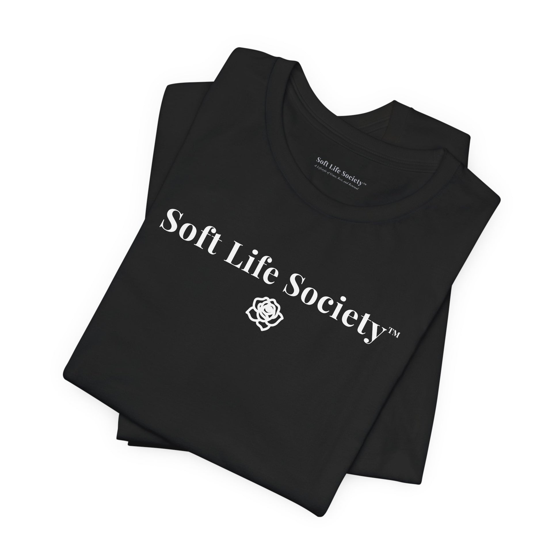 Folded black Soft Life Society t-shirt with white logo, minimalist cotton tee close up