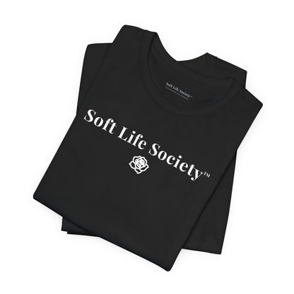 Folded black Soft Life Society t-shirt with white logo, minimalist cotton tee close up