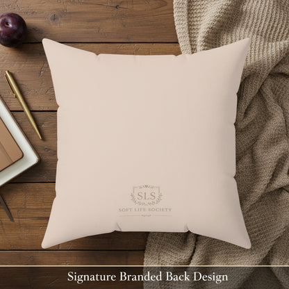 Beige pillow with 'SLS Soft Life Society' logo on a wooden surface with a pen, notebook, and fruit.