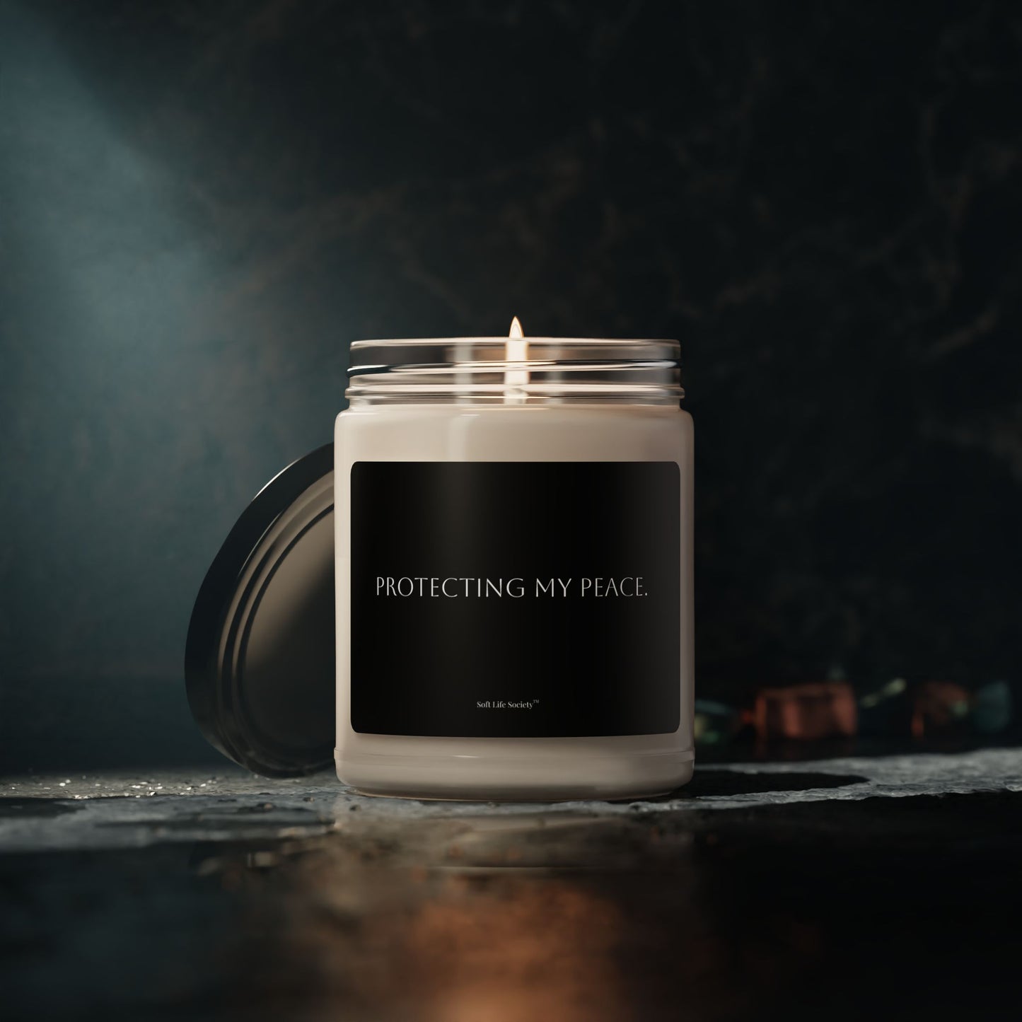 Candle in a glass jar with a black label on a dark background