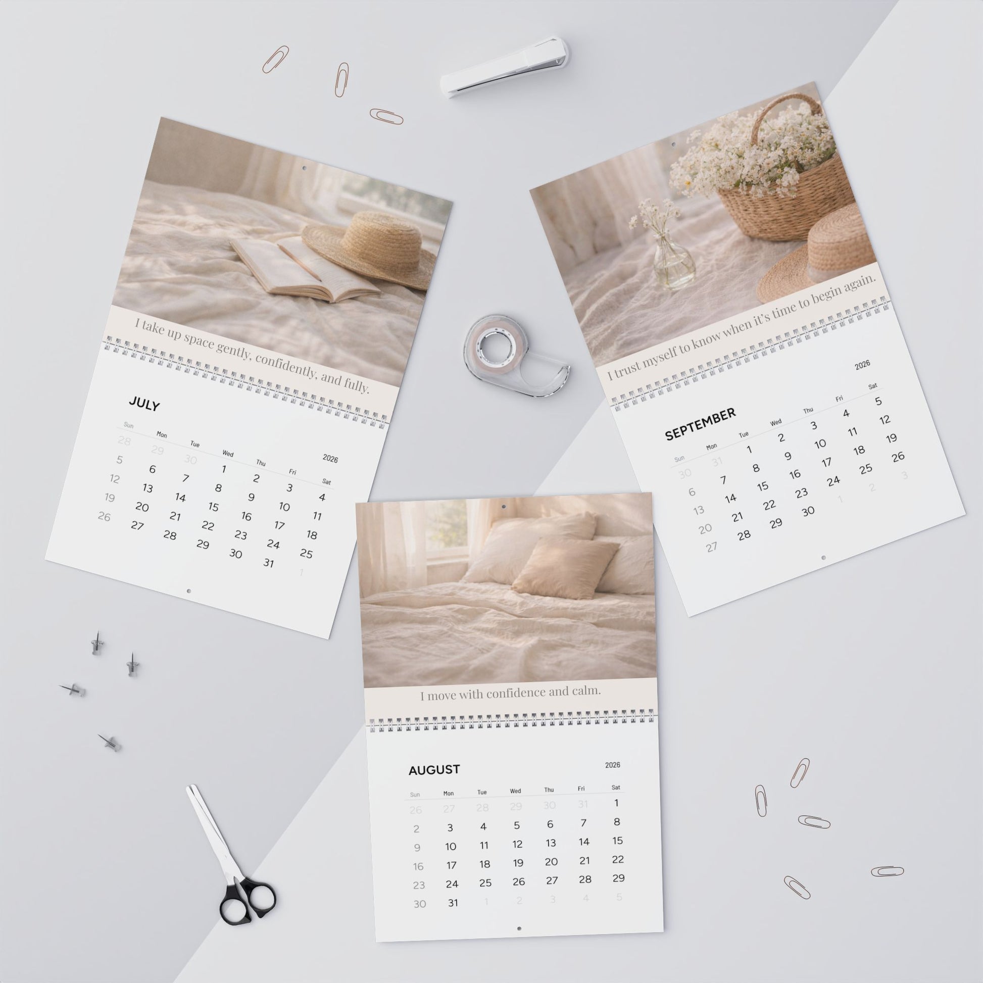 Three calendar pages for July, August, and September on a light gray surface with office supplies.