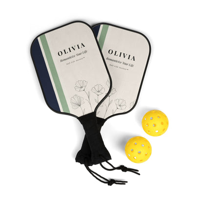 Two pickleball paddles with floral design and 'OLIVIA' branding, accompanied by two yellow pickleballs on a white background.