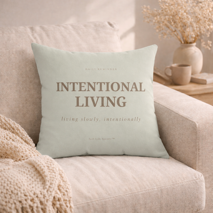 Light green pillow with 'Intentional Living' text on a beige couch.