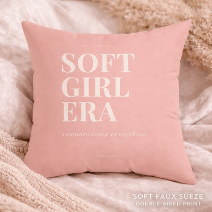 Pink pillow with 'SOFT GIRL ERA' text on a soft, beige background