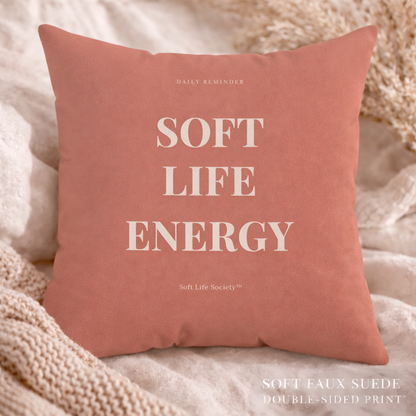 Pink pillow with 'Soft Life Energy' text on a soft background