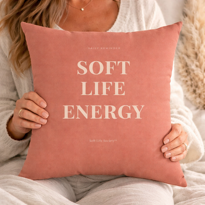 Person holding a pink pillow with 'Soft Life Energy' text