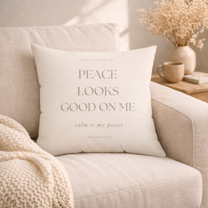 Decorative pillow with text on a beige couch in a cozy living room setting.