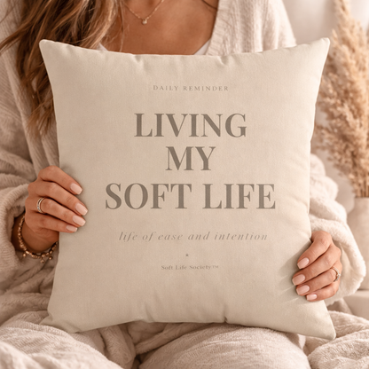 Person holding a pillow with 'Living My Soft Life' text