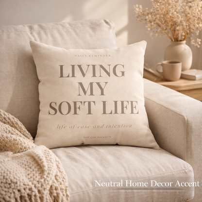 Beige pillow with 'Living My Soft Life' text on a beige sofa, with a neutral home decor theme.