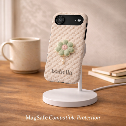 Phone case with floral design and 'Isabella' branding on a wooden surface with a mug and books.