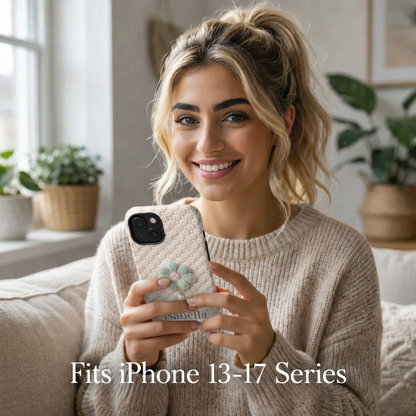 Woman holding a phone with a crochet floral case, sitting on a couch in a cozy living room.