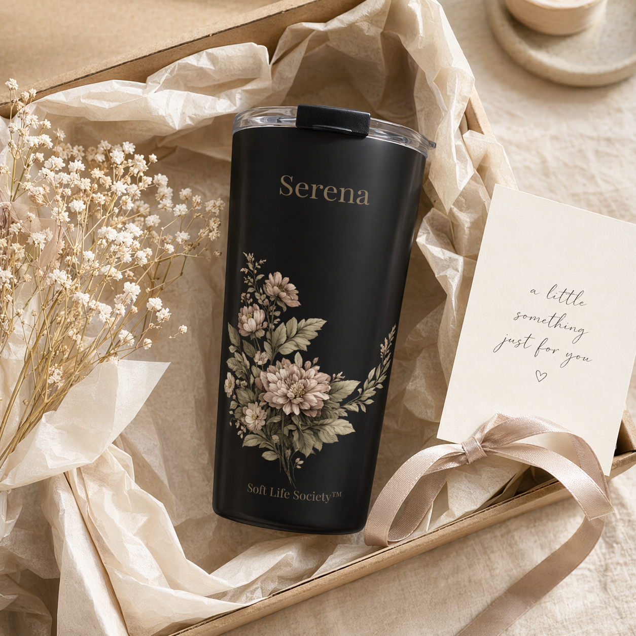 Black tumbler with floral design and 'Serena' branding on a beige background