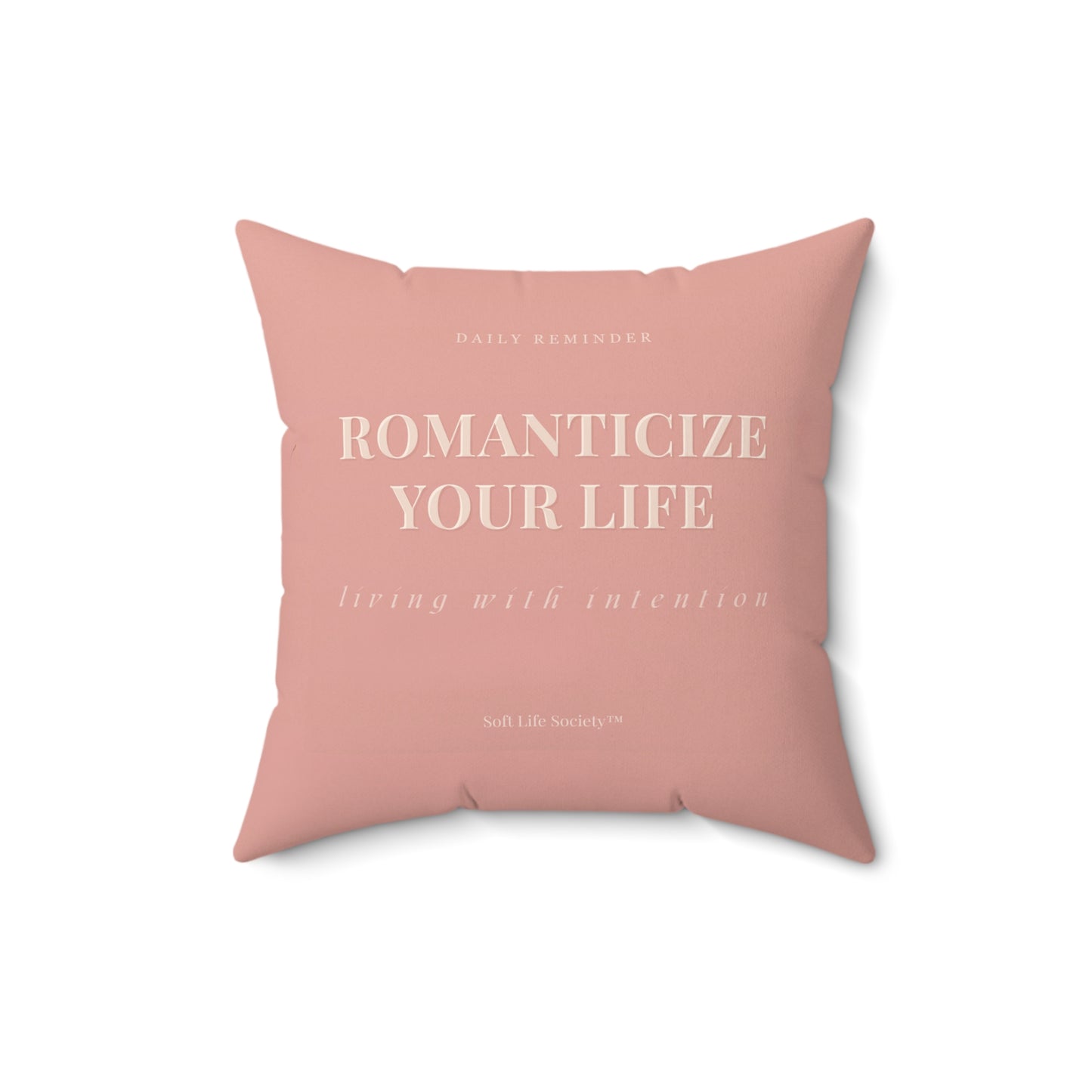 Pink pillow with motivational text on a white background