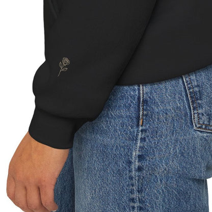 Close-up of subtle rose detail on the sleeve of a black Soft Life Society hoodie.