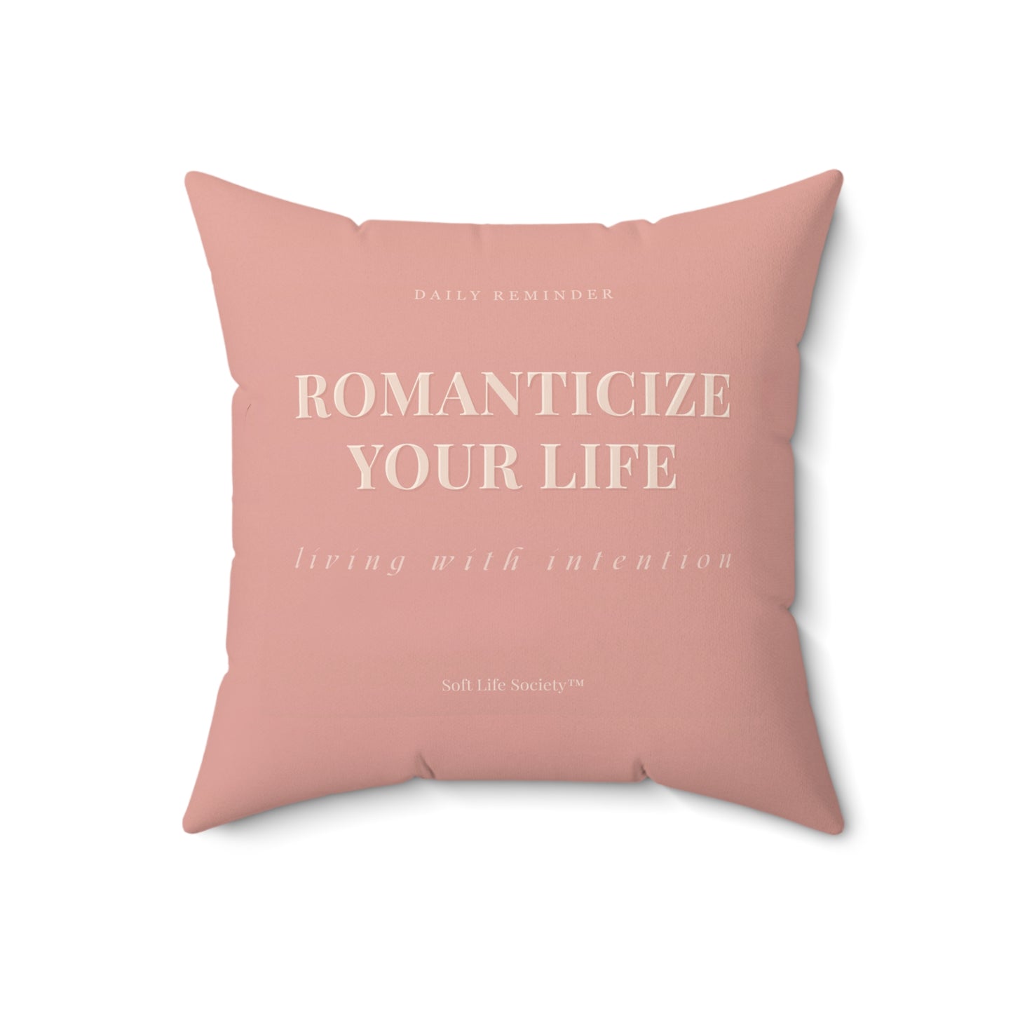 Pink pillow with motivational text on a white background