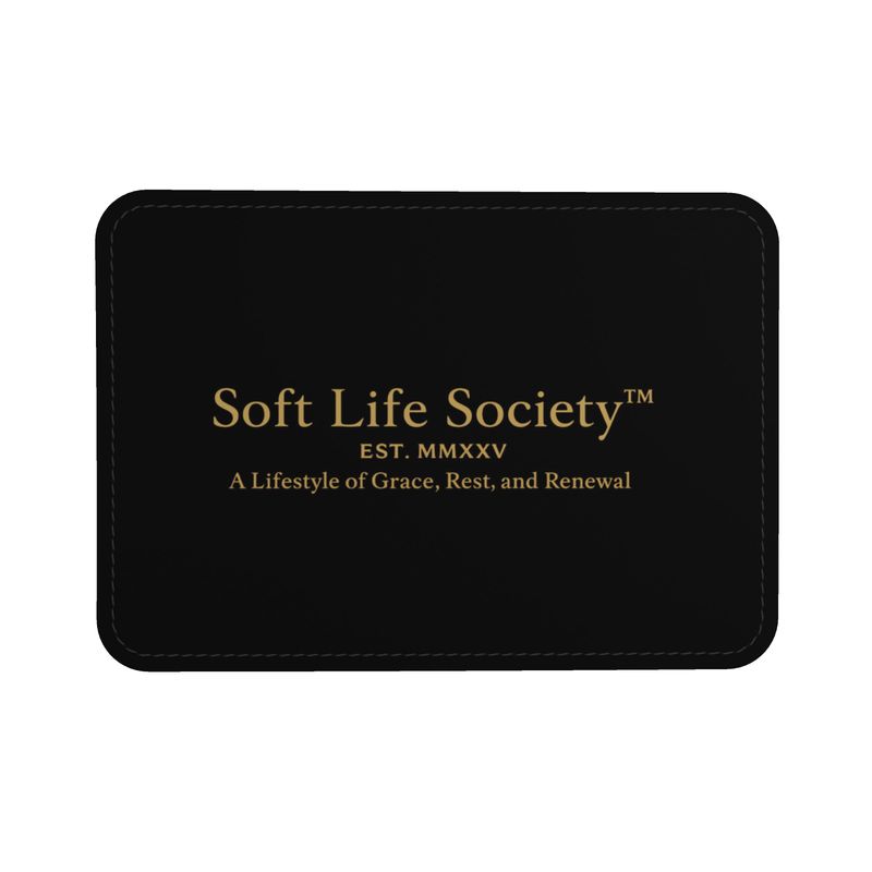 A black leather label featuring the gold Soft Life Society™ logo, reading “Soft Life Society™ — EST. MMXXV — A Lifestyle of Grace, Rest, and Renewal,” displayed with stitched edges.
