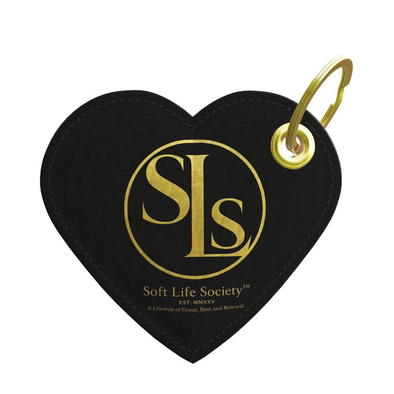 Black heart-shaped keychain with gold 'SLS' logo and text on a white background