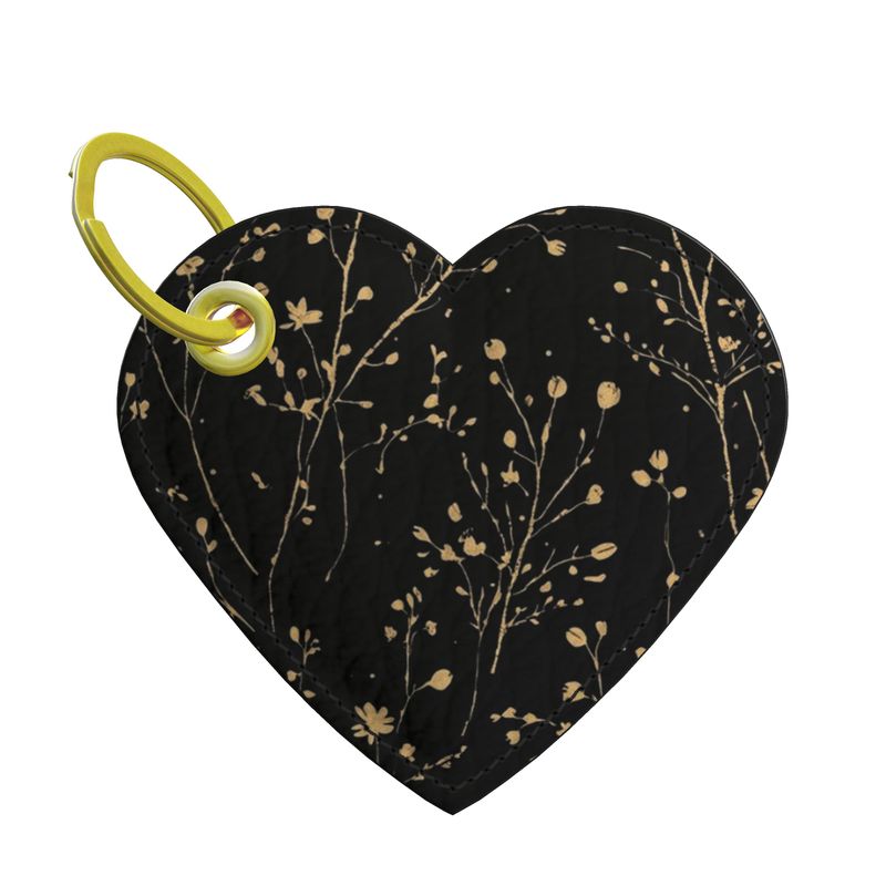 Heart-shaped leather keychain with floral pattern and yellow clip on a white background