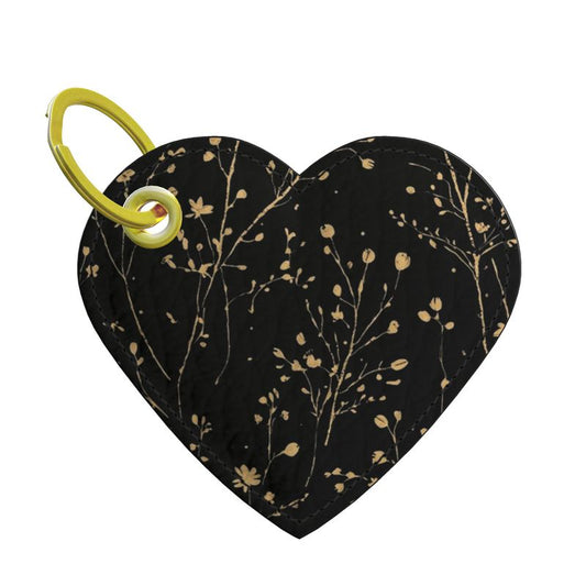 Heart-shaped leather keychain with floral pattern and yellow clip on a white background